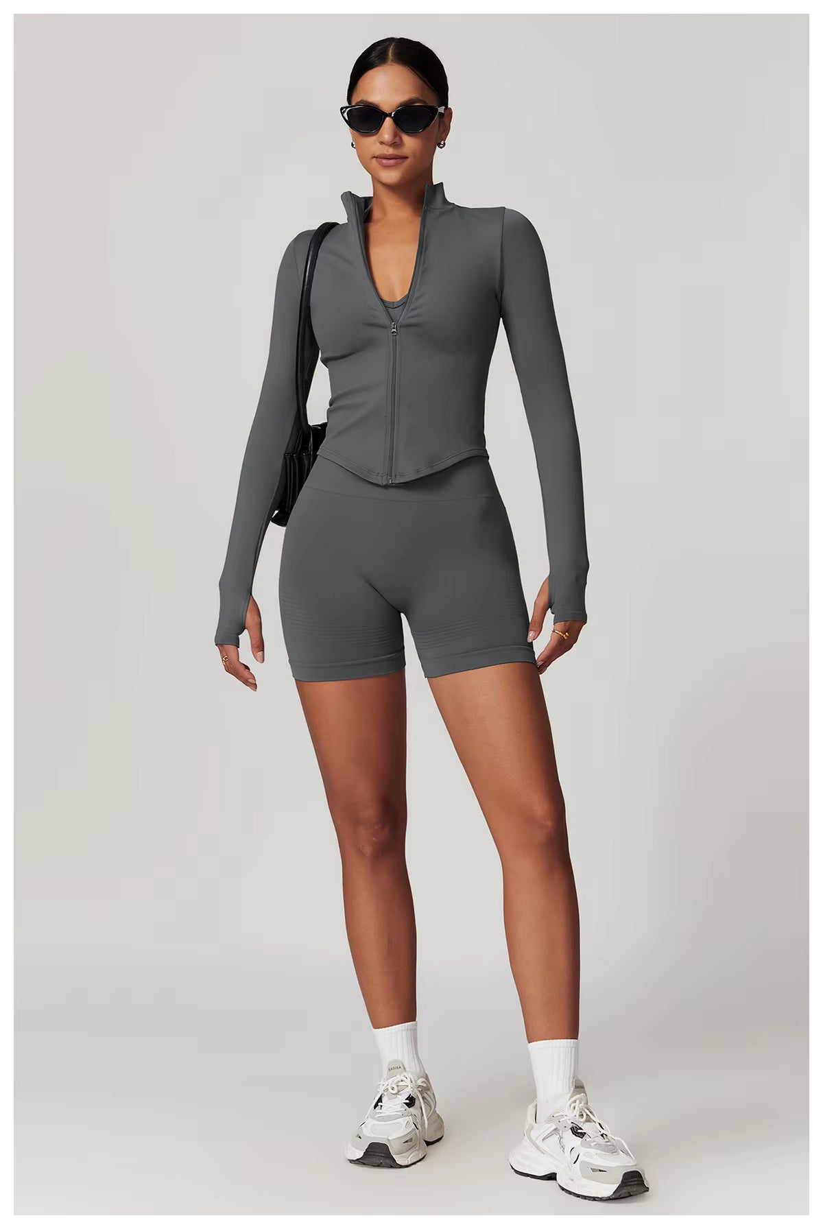 Person wearing a gray athletic outfit with a white background