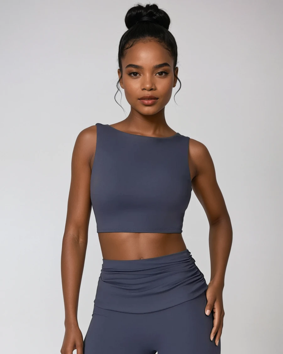 Woman wearing a dark gray athletic outfit on a light gray background