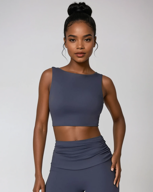 Woman wearing a dark gray athletic outfit on a light gray background